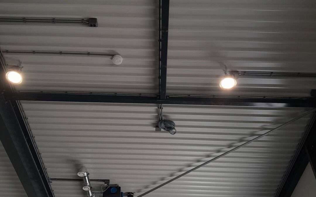Verlichting en zichtbare installatiedelen aan het plafond in een bedrijfspand